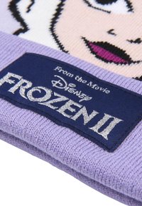 Berretto lavorato a maglia con grafica di un personaggio di Frozen II, in morbido colore lavanda e un'etichetta blu con la scritta "Frozen II" in lettere argentate.
