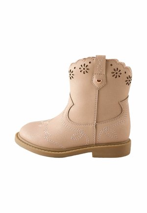 Light pink toddler cowboy boot with scalloped top, floral cut-out patterns, stitched leaf designs, and a small heart embellishment on the pull tab.