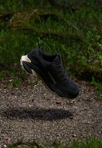 Czarne buty biegowe z teksturowaną cholewką, wzmocnionym czubkiem i jasnym, amortyzującym podbiciem, z logo po boku.
