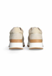 Beige tenisky s texturovaným svrškem, semišovými akcenty a bílou patou. Mají tan gumovou podrážku a viditelné logo na zadní straně.