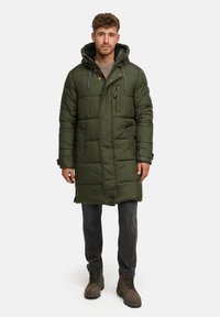 Zielona pikowana kurtka z kapturem, posiadająca zamek błyskawiczny z przodu, napy i boczne kieszenie. Tkanina ma gładką fakturę i jest w długości do połowy uda.