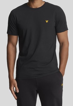 Black cotton t-shirt featuring a round neckline and short sleeves, adorned with a small yellow eagle logo on the left chest.