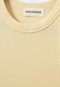 Beežist ribast kangast topp ümmarguste käistega. Omab sildikest, millel on nimeks "SOFIE SCHNOOR", õmmeldud kaelaossa.