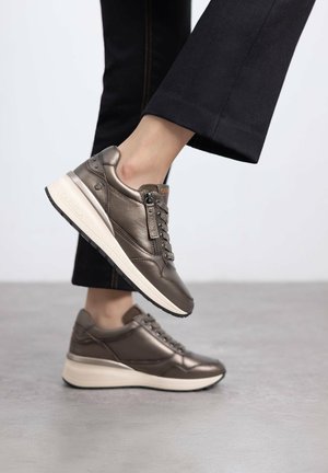 Zapatillas metálicas marrones con un acabado de cuero liso, diseño de cordones, cremallera lateral y una suela blanca acolchada para mayor comodidad.