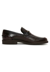 Bruine leren moccasin schoen met een gestructureerde afwerking, ronde neus, lage profiel en een decoratieve gesp als accent aan de voorkant.