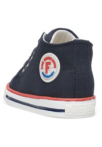 Sneaker in tela blu navy con un patch logo rosso e bianco, suola bianca con accenti rossi e un design semplice a lacci. Superficie superiore texturizzata.