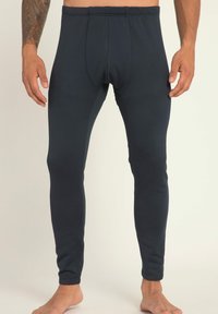 Dunkelblaues Leggings aus elastischem Stoff, mit einer schmalen Passform, elastischem Bund und sichtbaren Stichen entlang der Nähte.
