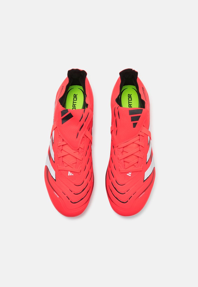 Helle rote Fußballschuhe mit einem schlanken Design, strukturiertem Obermaterial, schwarzen Akzenten und reflektierenden Streifen sowie einer neongrünen Einlegesohle.