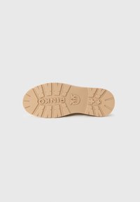 Talpă de shoe de culoare bej deschis cu caneluri adânci, numele brandului „PINKO” și logo-ul embosat în centru, prezentate pe un fundal alb.