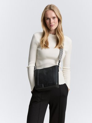 Borsa a tracolla in pelle nera con una tracolla regolabile a motivo, forma rettangolare, texture liscia e design minimalista.
