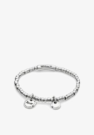 Bracelet composé de perles couleur argent avec une barre centrale lisse. Comprend deux breloques : un cœur et un cercle gravé "Amor".