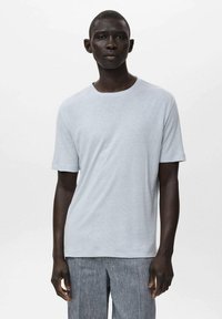 Light gray short-sleeve t-shirt made of soft fabric with a round neckline, paired with textured gray pants. Simple, minimal design.