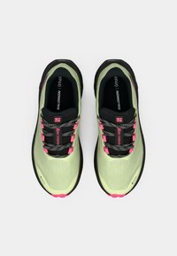 Ανοιχτό πράσινα παπούτσια τρεξίματος με μαύρες και ροζ λεπτομέρειες, υφασμάτινο επάνω μέρος με υφή, ανθεκτική μαύρη σόλα και αντανακλαστικά κορδόνια.