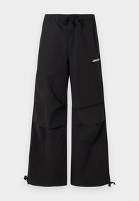 Μαύρο παντελόνι με φαρδιά κούμπωμα, ελαστική μέση, κορδόνια στα τελειώματα και λευκό λογότυπο στην πάνω μηρό.