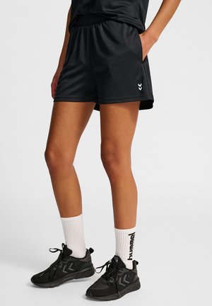 Black sports shorts with an elastic waistband, made of smooth fabric. Includes white chevron logo detail and side pockets.