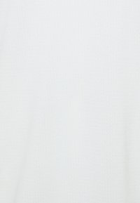 Tejido blanco texturizado con un patrón sutil y en relieve. El material parece ligero y transpirable, adecuado para ropa casual.