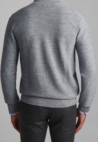 Pull en tricot gris avec un col et des poignets côtelés, présentant un motif texturé et une coupe ajustée à la taille.