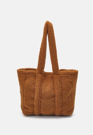 Bruine gestructureerde totebag met twee lange handvatten, gemaakt van zachte, wolachtige stof.