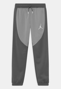 Dwukolorowe szare dresy sportowe z elastycznym paskiem w talii, sznurkiem i mankietami na kostkach, z białym logo Jumpman na prawej udzie.