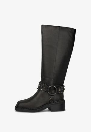 Bota alta de couro preto com um cinto com studs e acabamentos em metal, fivela redonda e salto robusto. Superfície lisa.