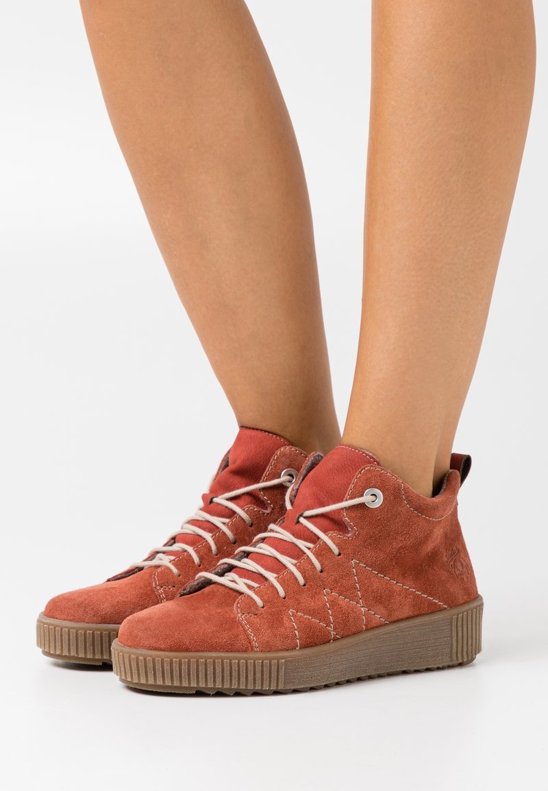 Röda mockaskinn hög-top sneakers med beige snören, rund tå, texturerad gummiyttersula och subtila sömmar på sidorna.