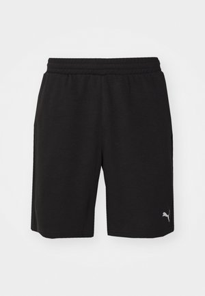 Zwarte sportieve shorts van zacht materiaal met een elastische tailleband, uitgerust met zijzakken en een klein reflecterend logo aan de onderlinkerzijde.