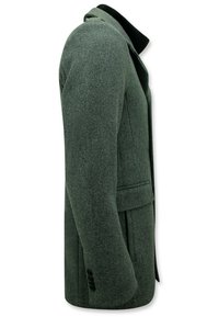 Grijs-groen wollen jas met een gestructureerde silhoutte, ingesneden kraag en vo pockets. Bevat zwarte knoopaccenten op de mouwen.