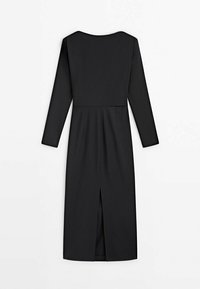 Robe noire à manches longues, col arrondi, et fente frontale. Réalisée en tissu lisse avec un corsage ajusté et une jupe évasée.