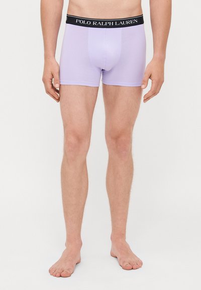 Λιλά σλιπ με μαύρη ζώνη που φέρει το λογότυπο "POLO RALPH LAUREN". Το ύφασμα είναι λείο με άνετη εφαρμογή.