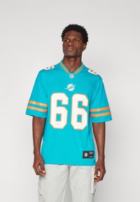Μια τυρκουάζ φανέλα NFL με πορτοκαλί ρίγες, με τον αριθμό 66 και ένα λογότυπο δελφινιού. Ο ιστός φαίνεται απαλός με αθλητική εφαρμογή.