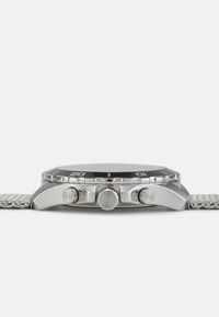Silberne Edelstahl-Uhr mit schwarzem Zifferblatt, drei kleinen Zifferblättern und zwei Seitentasten. Das Armband hat ein gliederförmiges Metalldesign.