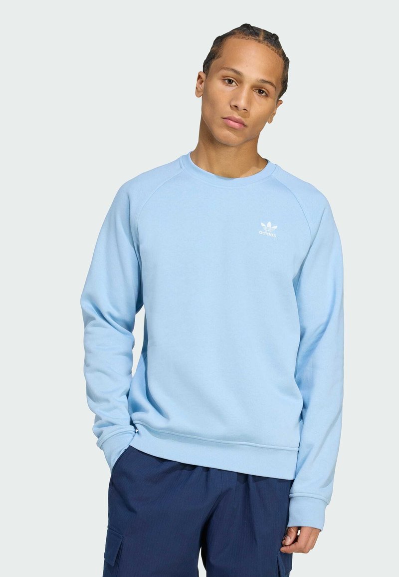 Lyseblå sweatshirt med lange ærmer, rund halsudskæring, ribbede manchetter og kant. Har et lille hvidt logo på brystet. Casual design.