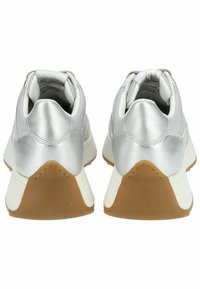 Paire de baskets argentées vues de dos, avec des semelles intermédiaires blanches et des semelles extérieures en caoutchouc marron.