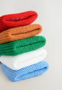 Stos pięciu złożonych ręczników bawełnianych w kolorach czerwonym, pomarańczowym, zielonym, białym i niebieskim. Każdy ręcznik ma strukturalną teksturę i jest starannie ułożony.