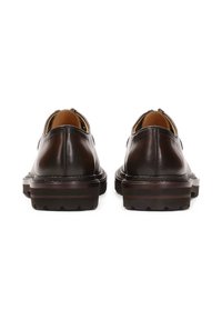 Ruske nahkasaapaat, joilla on sileä pinta, matala profiili ja tukevat kumipohjat, joissa on teksturoitu urakuviot. Ei näkyvää brändäystä.