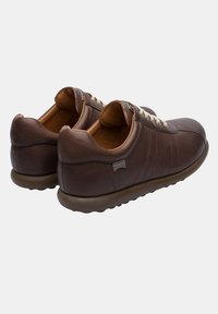 Brown leather sneakers with a smooth texture, rounded toe, and light laces. Features a cushioned sole and subtle side stripes.