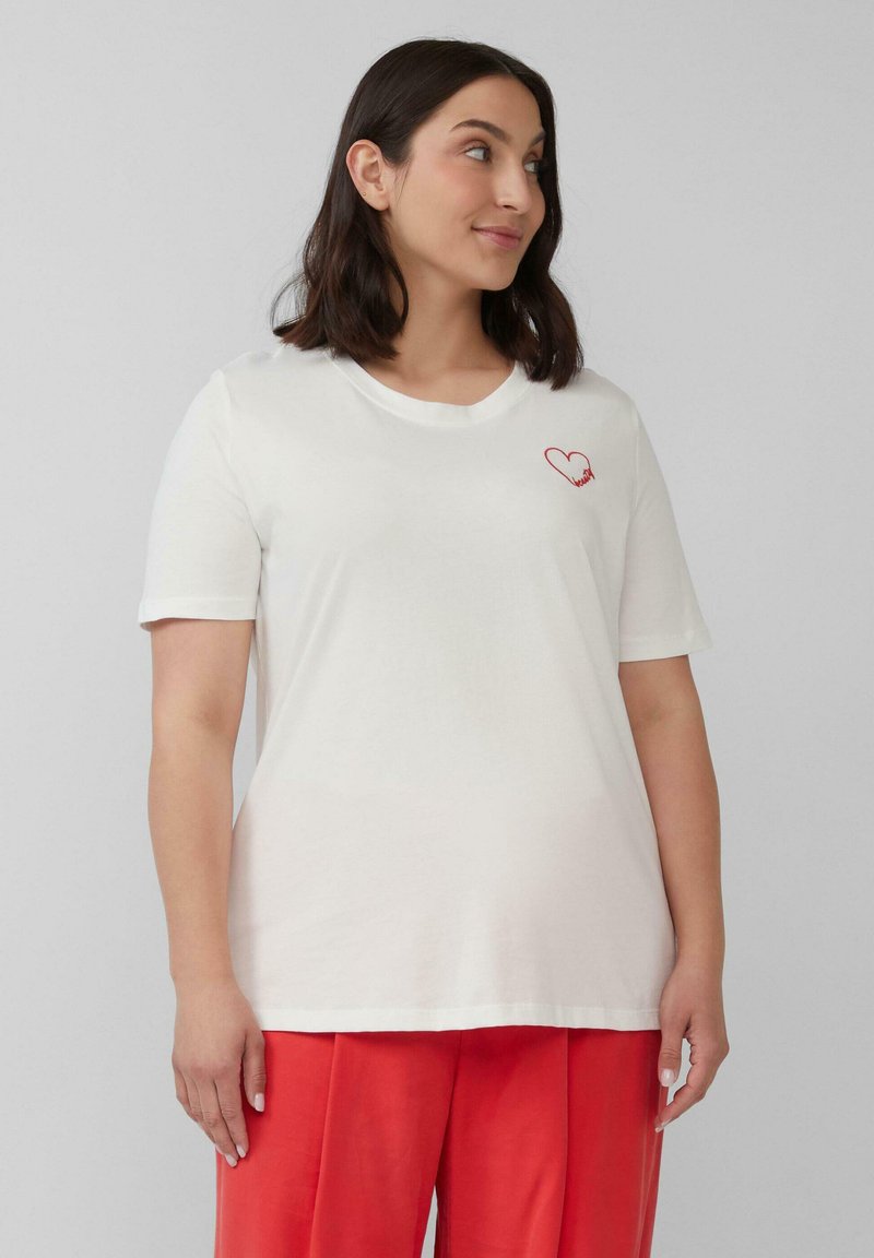 Weißes Baumwoll-T-Shirt mit kurzen Ärmeln, versehen mit einem kleinen roten gestickten Herzen auf der linken Seite. Lockere, lässige Passform.