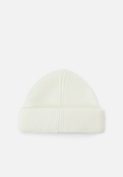 Bonnet en tricot côtelé blanc avec revers, présenté à plat sur un fond blanc.