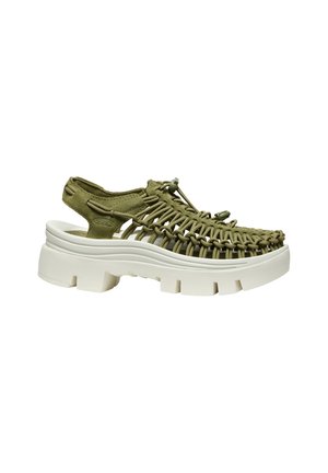 Sandale tissée vert olive avec lacet ajustable et semelle blanche épaisse et chunky, talon ouvert et design à bout ouvert.