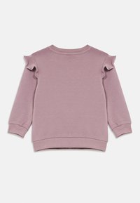 Maglione lungo a maniche di colore lilla per bambini, con dettagli in ruffles sulle spalle e polsini e orlo a coste, steso su uno sfondo bianco.