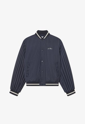 Jūrų mėlynos spalvos striukė su smulkiomis juostelėmis, apykaklė, rankovės ir apatinė dalis pagamintos iš raištelių; turi priekinę užsegimą su spaudėmis ir šonines kišenes.