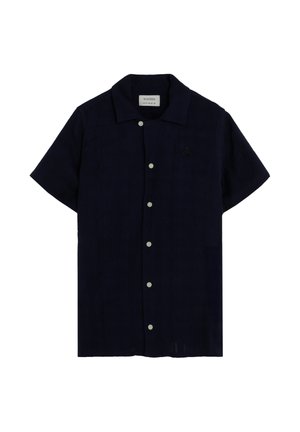 Camisa azul marino de manga corta con botones y cuello, con un pequeño logo bordado en el pecho izquierdo.
