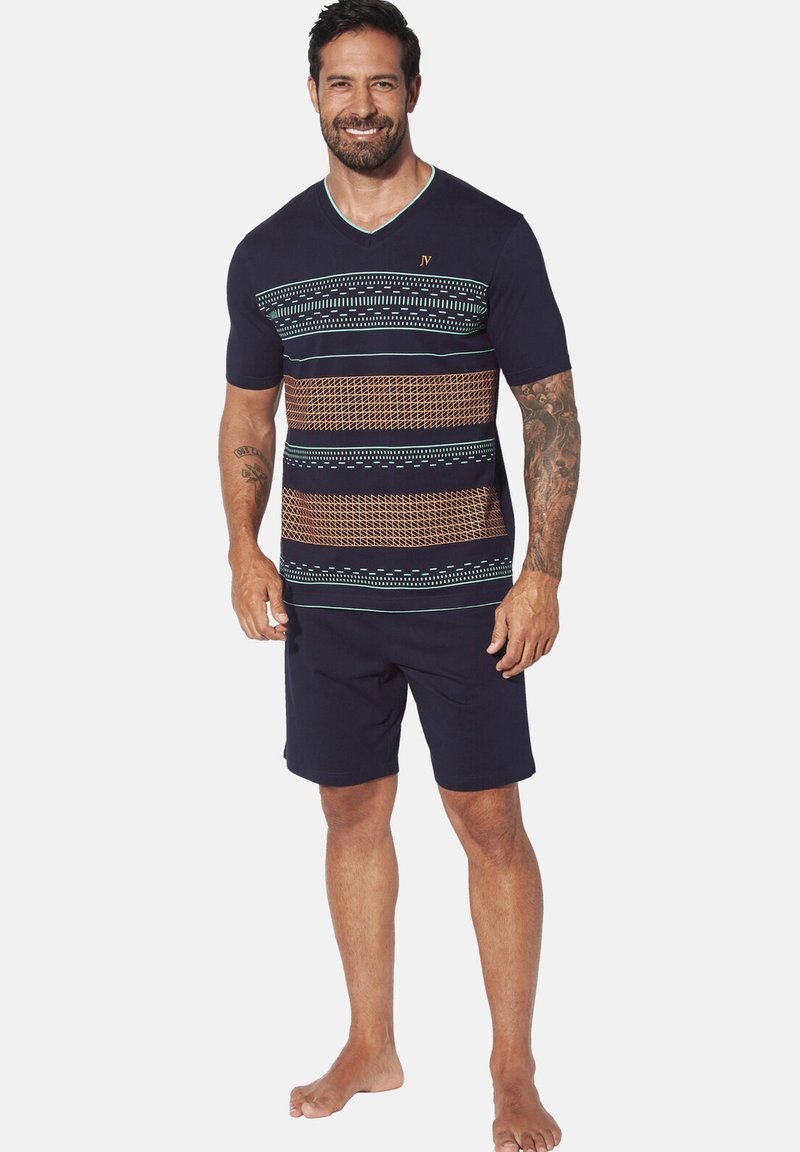 Navy short-sleeve V-neck shirt featuring geometric patterns in turquoise and brown. Worn with dark shorts, no shoes.