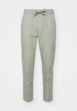 Kerged rohelised, kitsenevad püksid elastse vöökoha ja reguleeritava paelaga; valmistatud pehmest, tekstuurist kangast mugavuse tagamiseks.