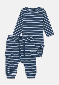 Gestreiftes Baby-Outfit mit einem langärmeligen Body und passenden Hosen. Hergestellt aus weichigem Baumwollstoff in Marineblau mit weißen Streifen, inklusive Kordelzug und Taschen.