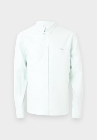 Λευκό πουκάμισο με μακριά μανίκια σε ανοιχτό μπλε χρώμα, με γιακά και μικρό κεντημένο λογότυπο αλεπούς στο αριστερό στήθος.