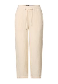 Light beige, textured pants with an elastic waistband and drawstring. Features two side pockets and tapered, ankle-length design.