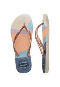 Havaianas japonke z teksturirano podlogo s pastelno obarvanimi bloki in bronasto kovinsko naramnico. Lahka zasnova za vsakodnevno nošenje.