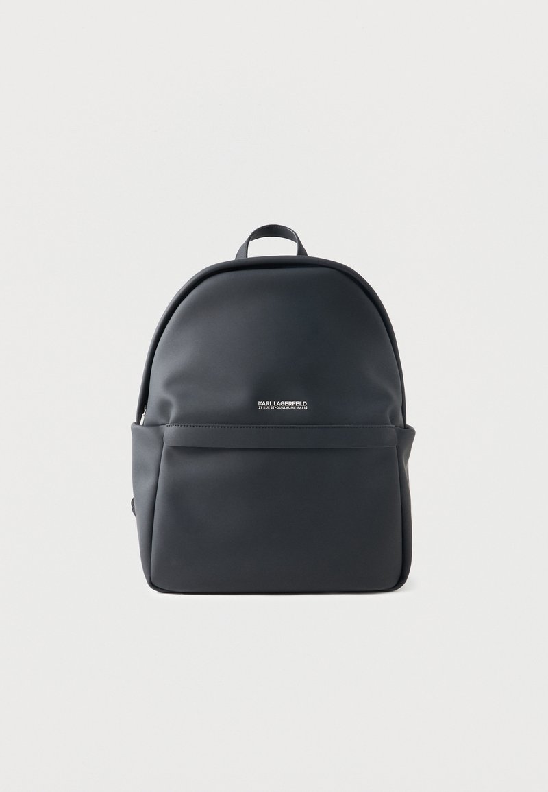 Sac à dos noir Karl Lagerfeld avec poche zippée devant et poignée supérieure, présenté sur fond blanc.