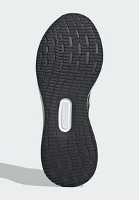 Czarna gumowa podeszwa do butów sportowych z teksturowanym wzorem bieżnika, z białym okrągłym wycięciem i gładką krawędzią.
